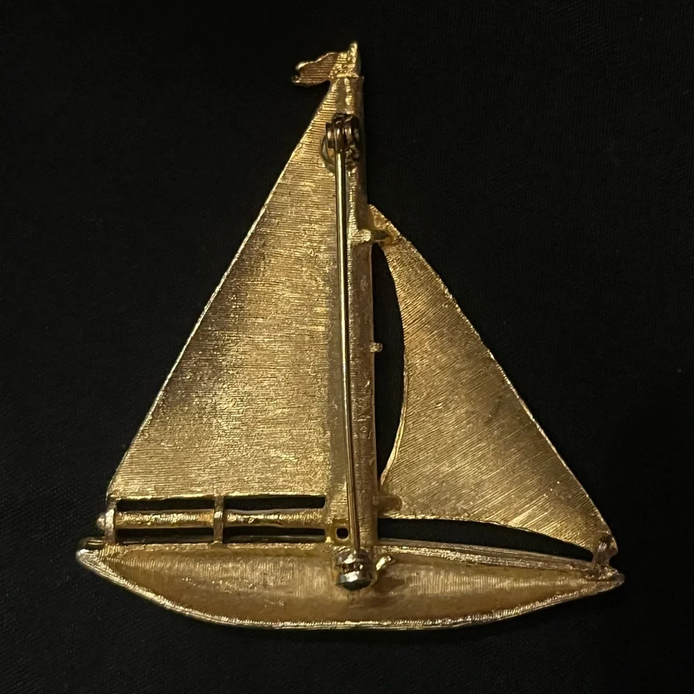 Gold tone sailboat brooch with white and blue enamel